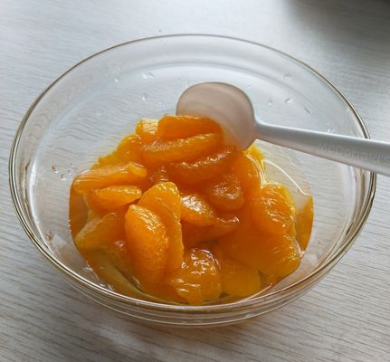 Segmentos de mandarina enlatada de la cosecha de 2025 con naranjas frescas de color amarillo dorado, listos para comer